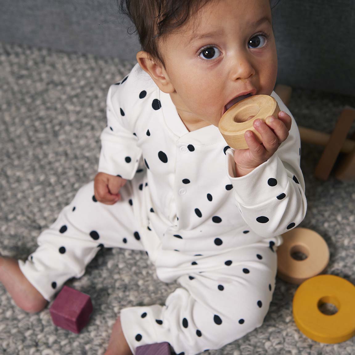 Baby playing in our sleepsuits with black and white dots