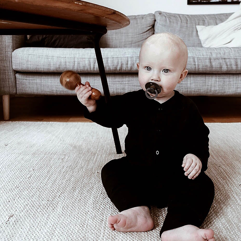 Baby in black sleepsuit from The Sleepy Collection. Photo by Cecilia Koch