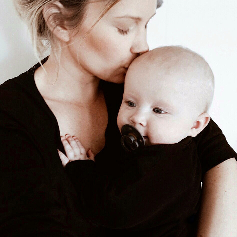 Mother and baby, wearing black sleepwear from The Sleepy Collection. Photo by Cecilia Koch