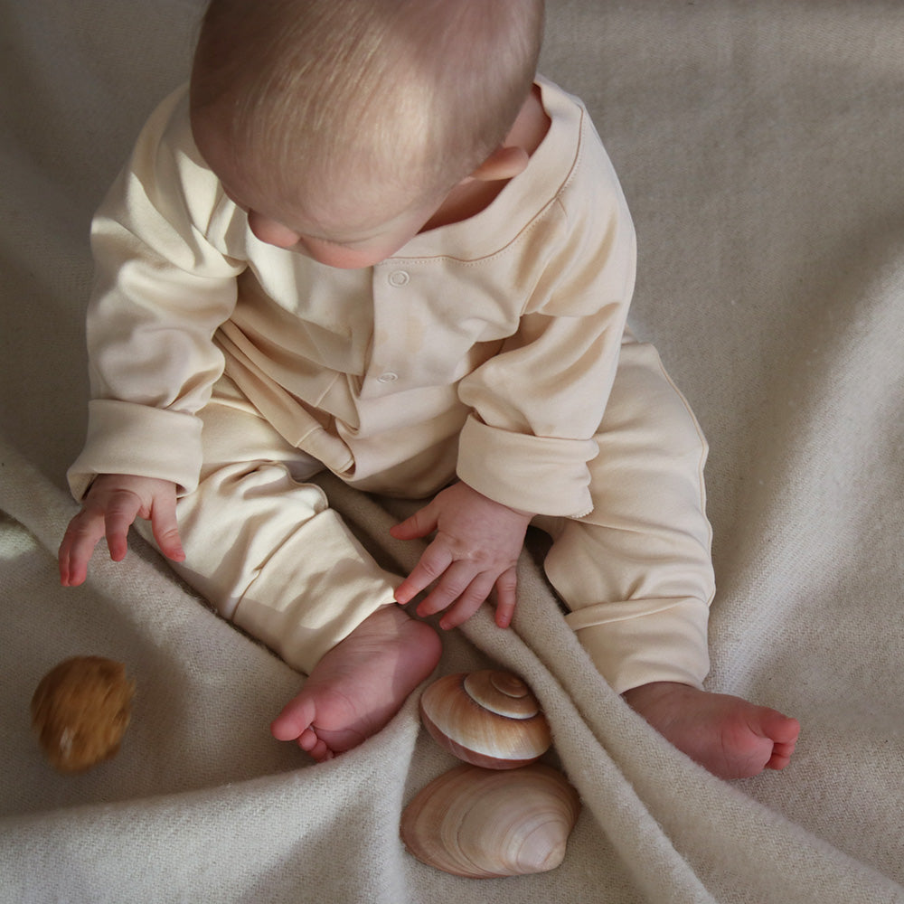 Baby wearing baby sleepsuit in natural color