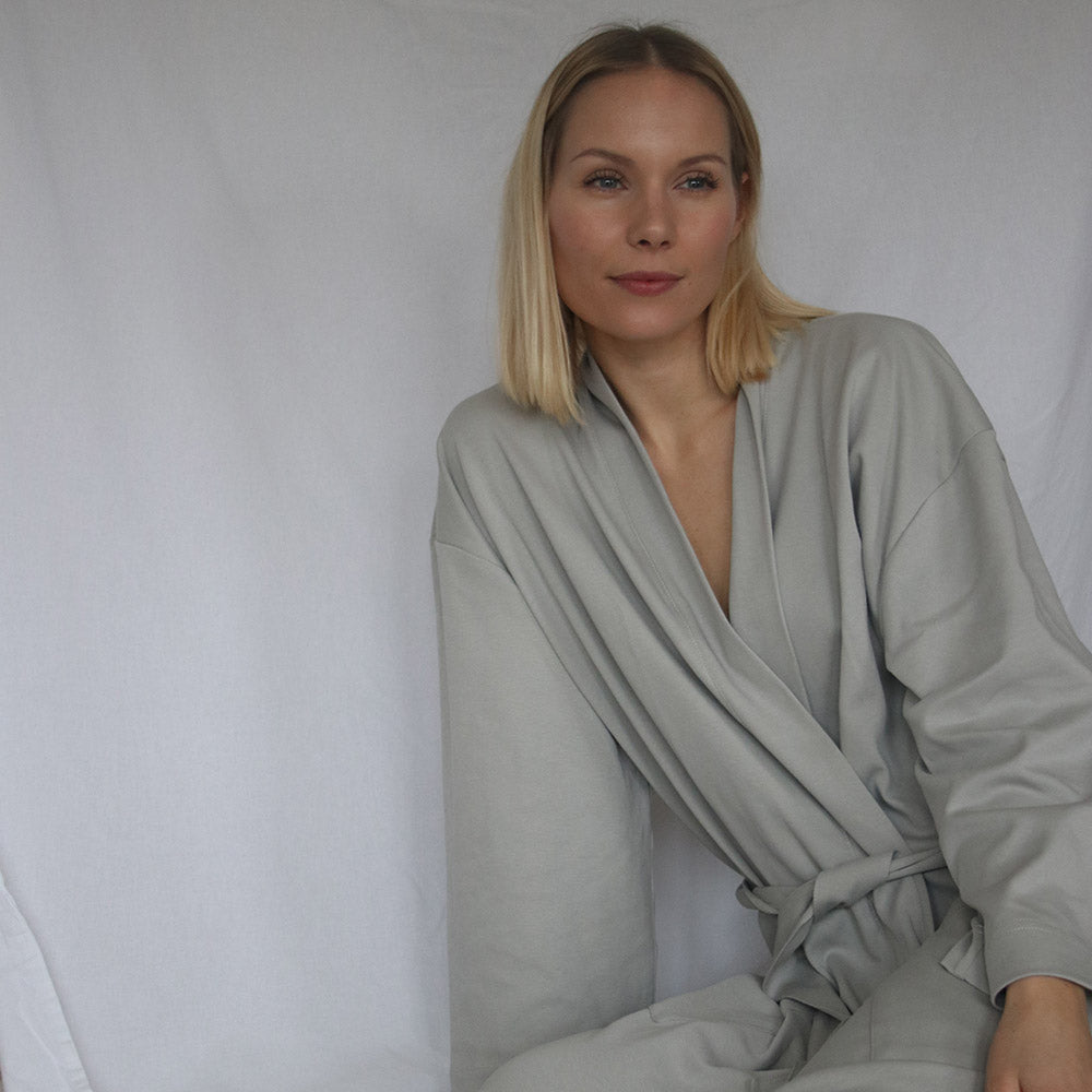 A blond woman wearing light grey morning robe by The Sleepy Collection