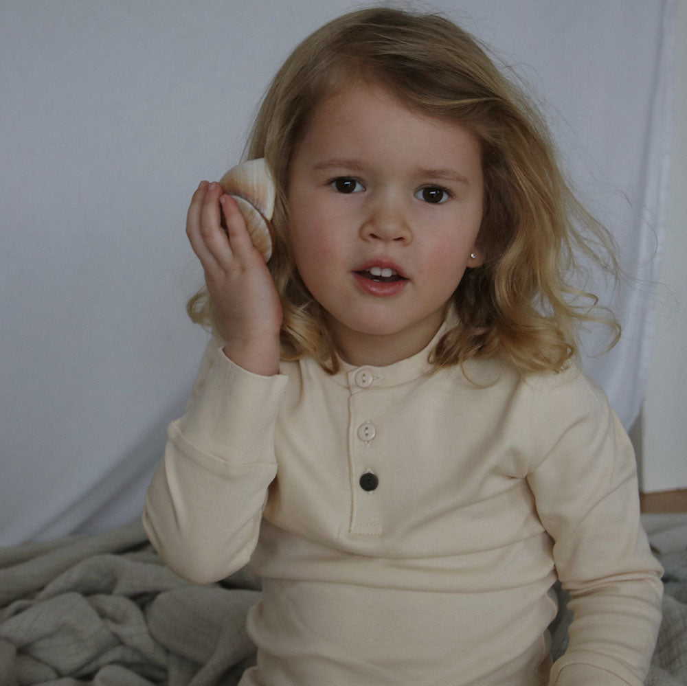 Girl wearing SS20 sleepwear in color sand, from The Sleepy Collection